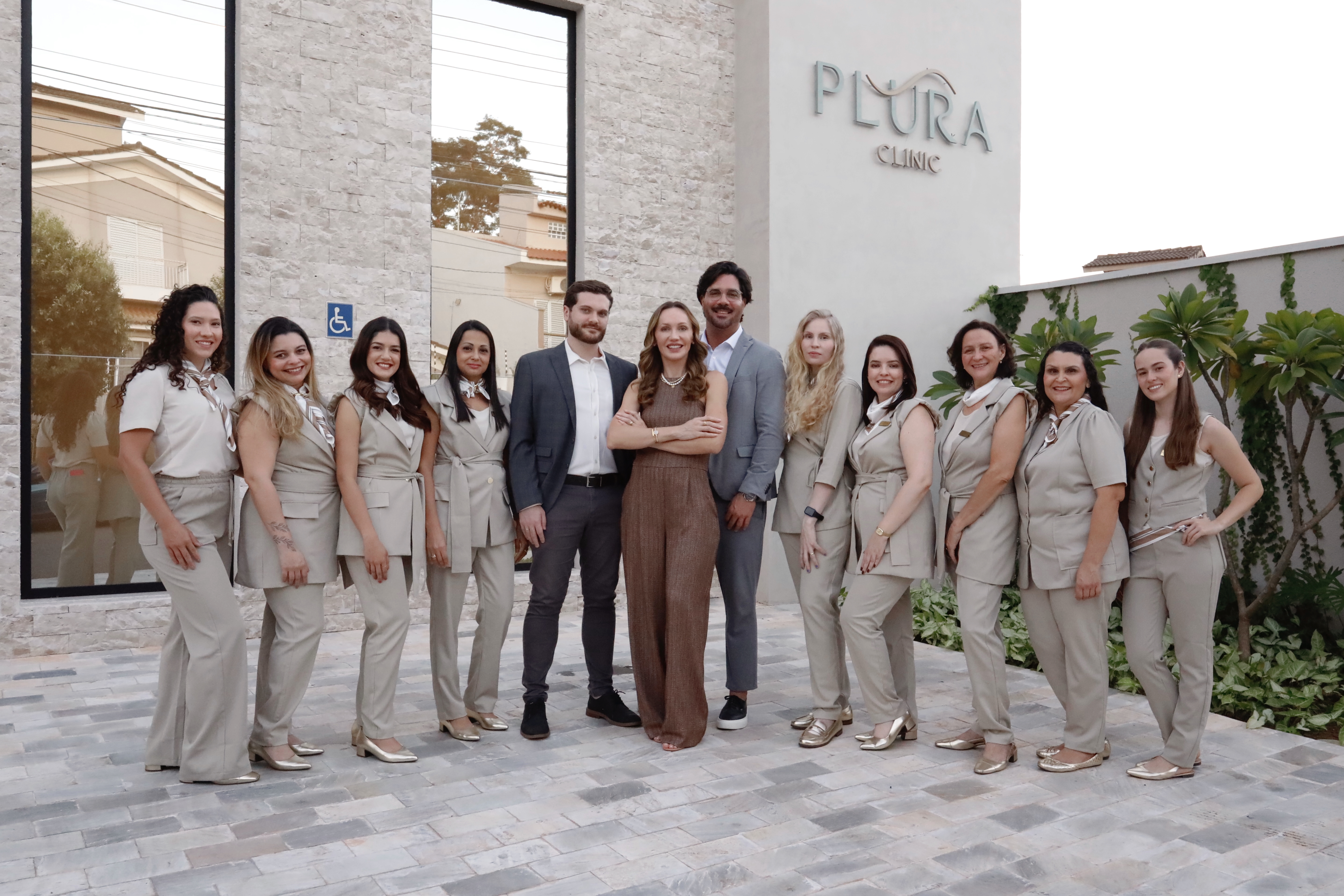 Equipe Plura Clinic em frente à fachada